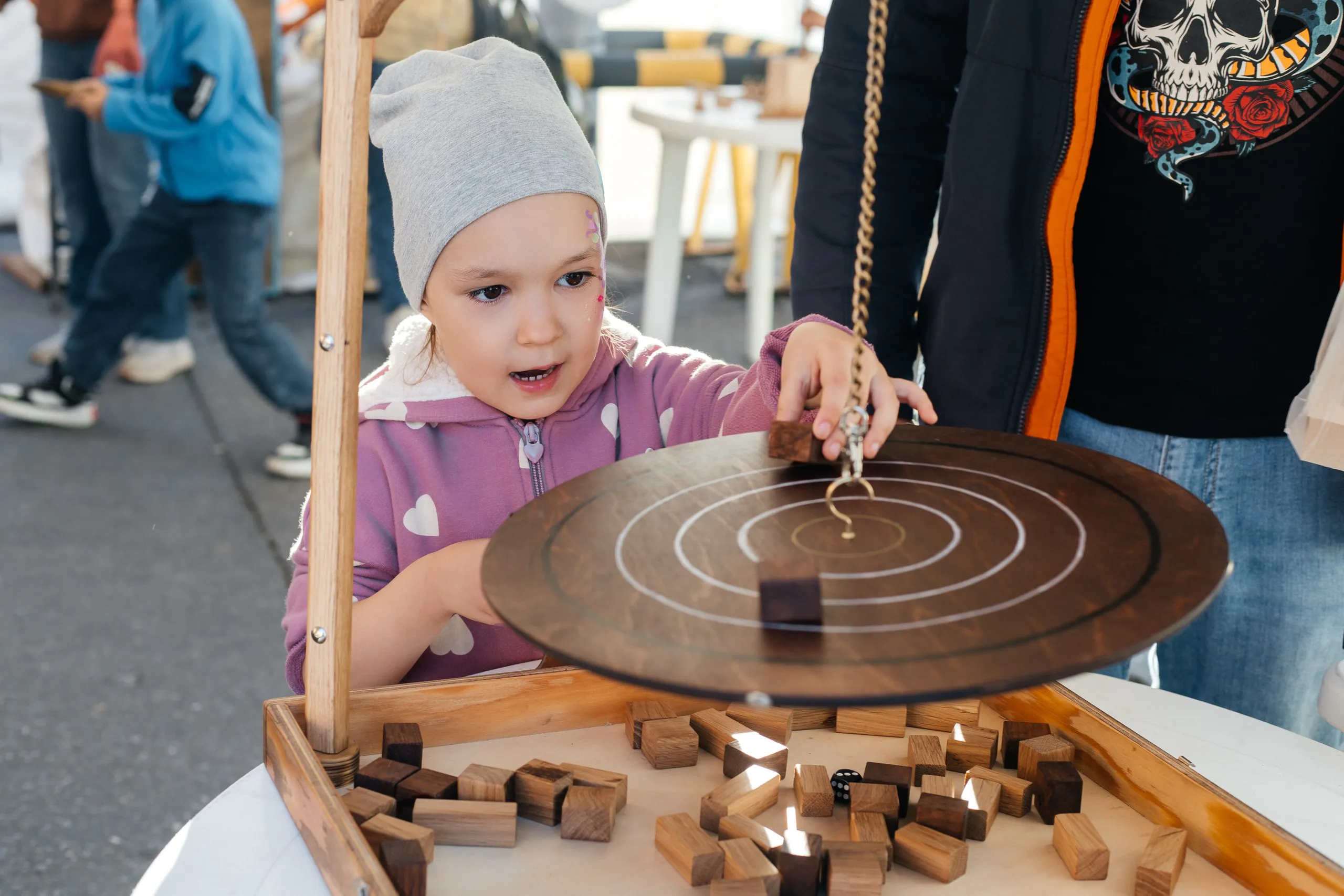 Девочка пробует игру «Балансир» на EcoFest